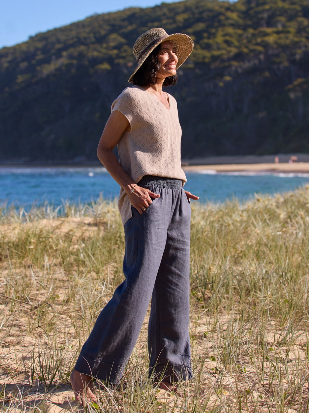 Woman standing on a beach with mountains in the background