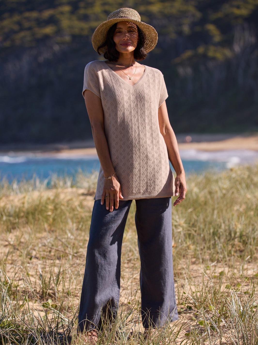 Woman standing in a field with a scenic background
