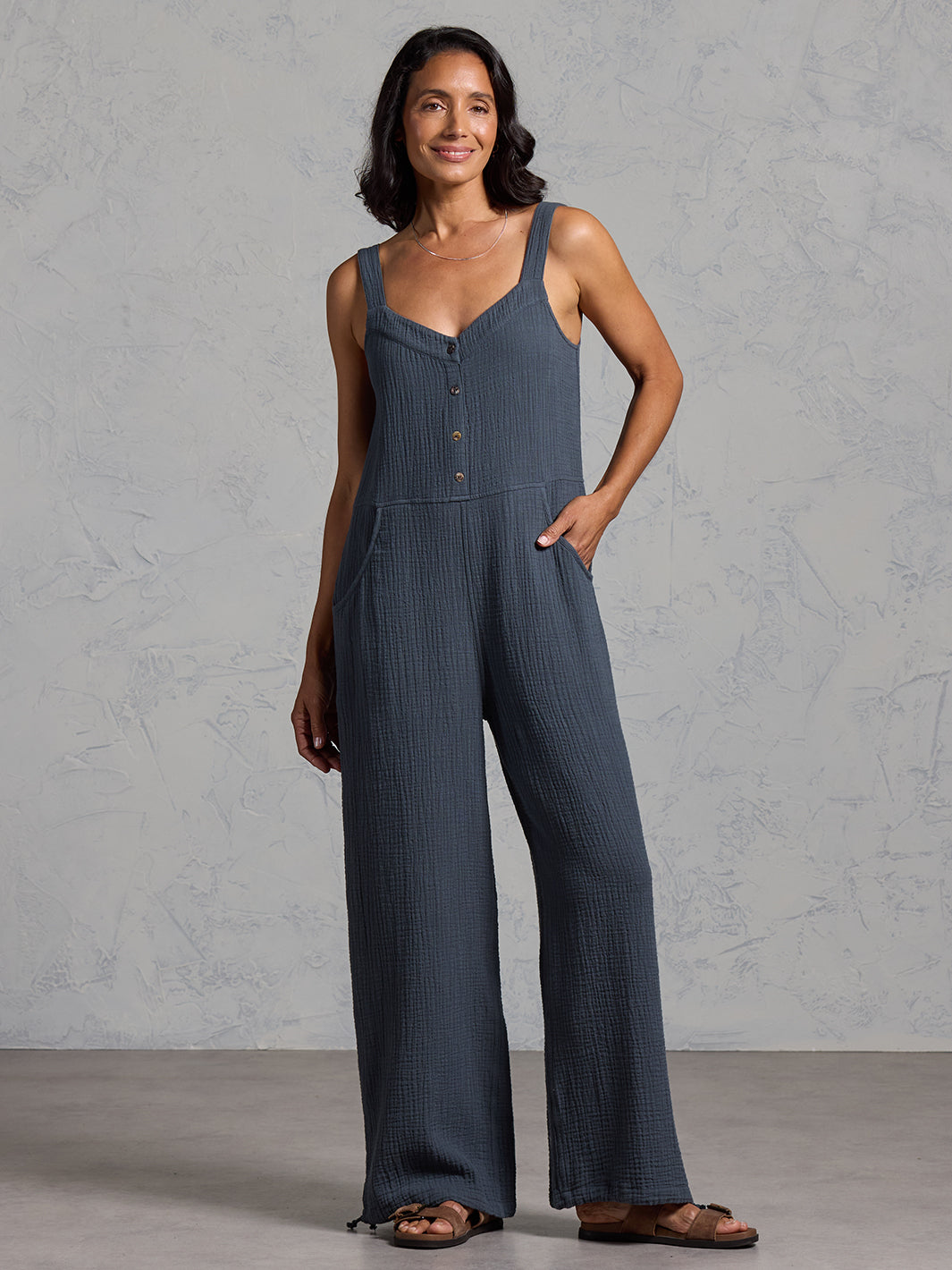 A woman wearing a charcoal cotton jumpsuit from Nomad the Label