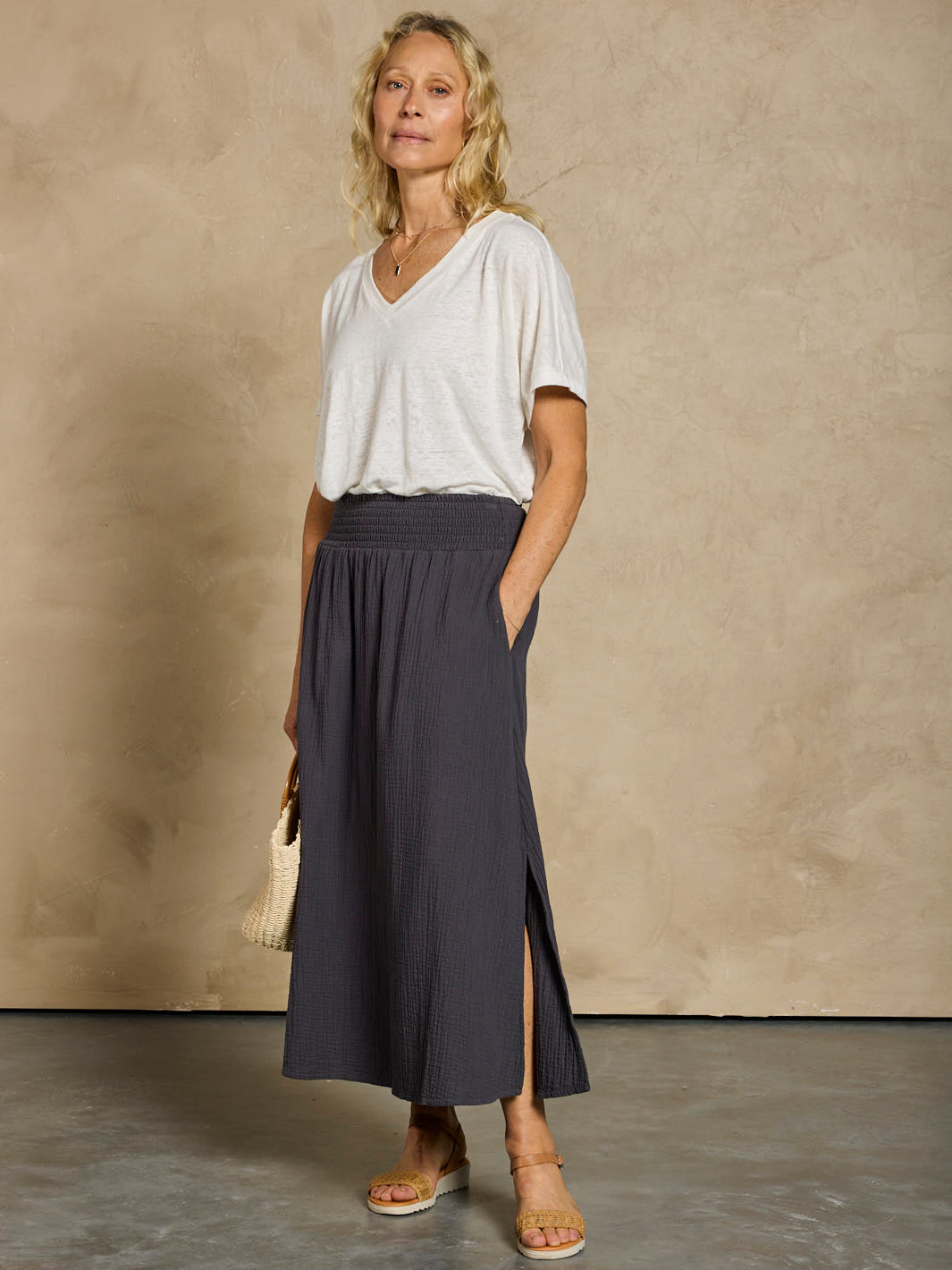 Woman wearing a white linen top and black cotton skirt.