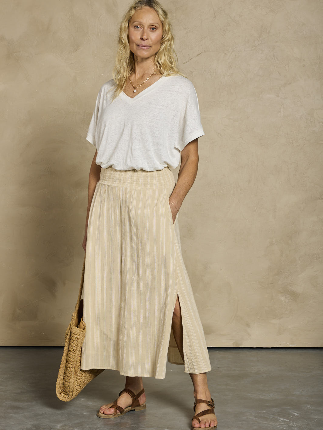 Woman wearing a white linen top and beige cotton skirt