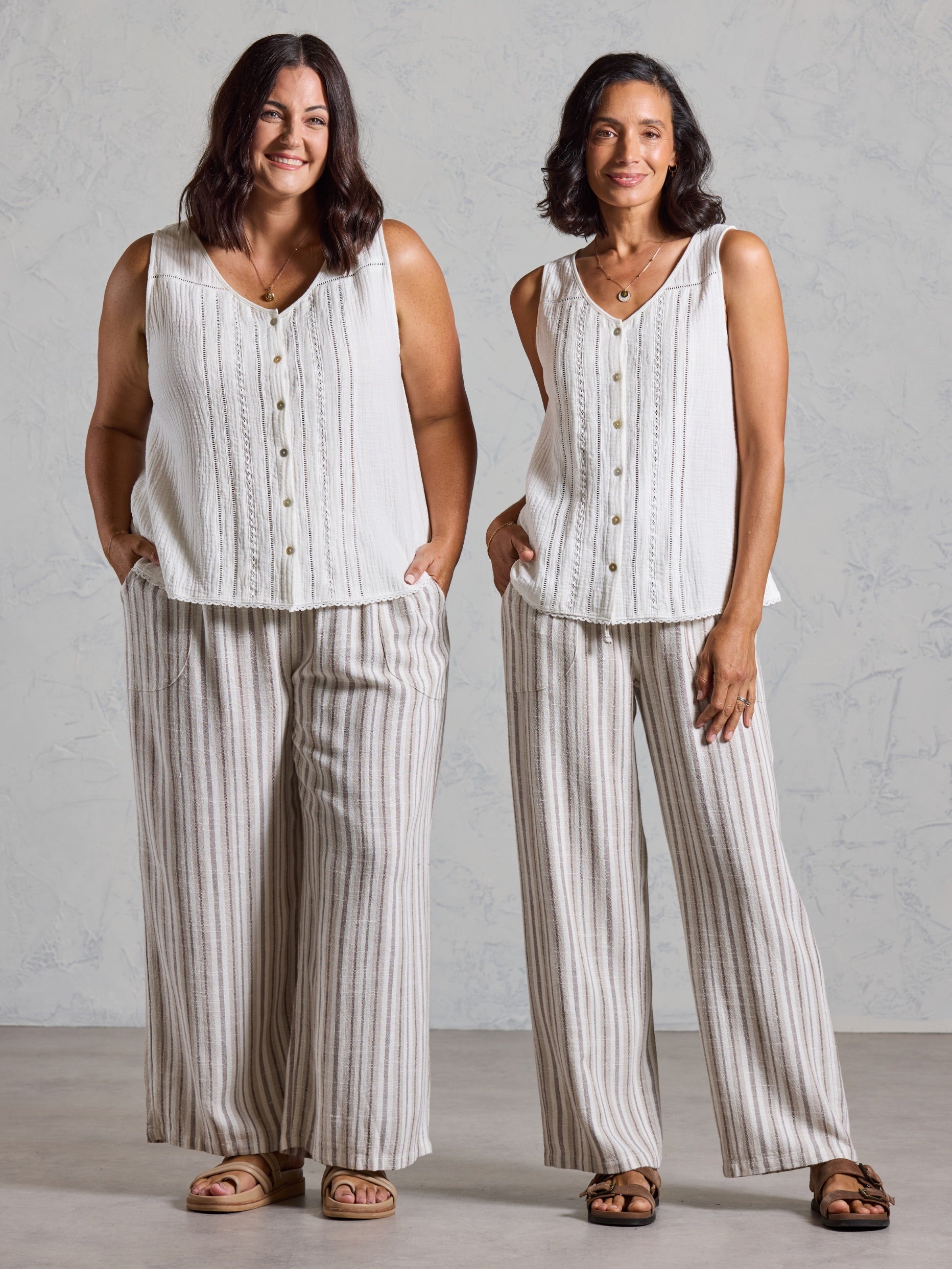 Two models wearing the Ceres Organic Cotton Top in coconut with striped wide leg linen pants