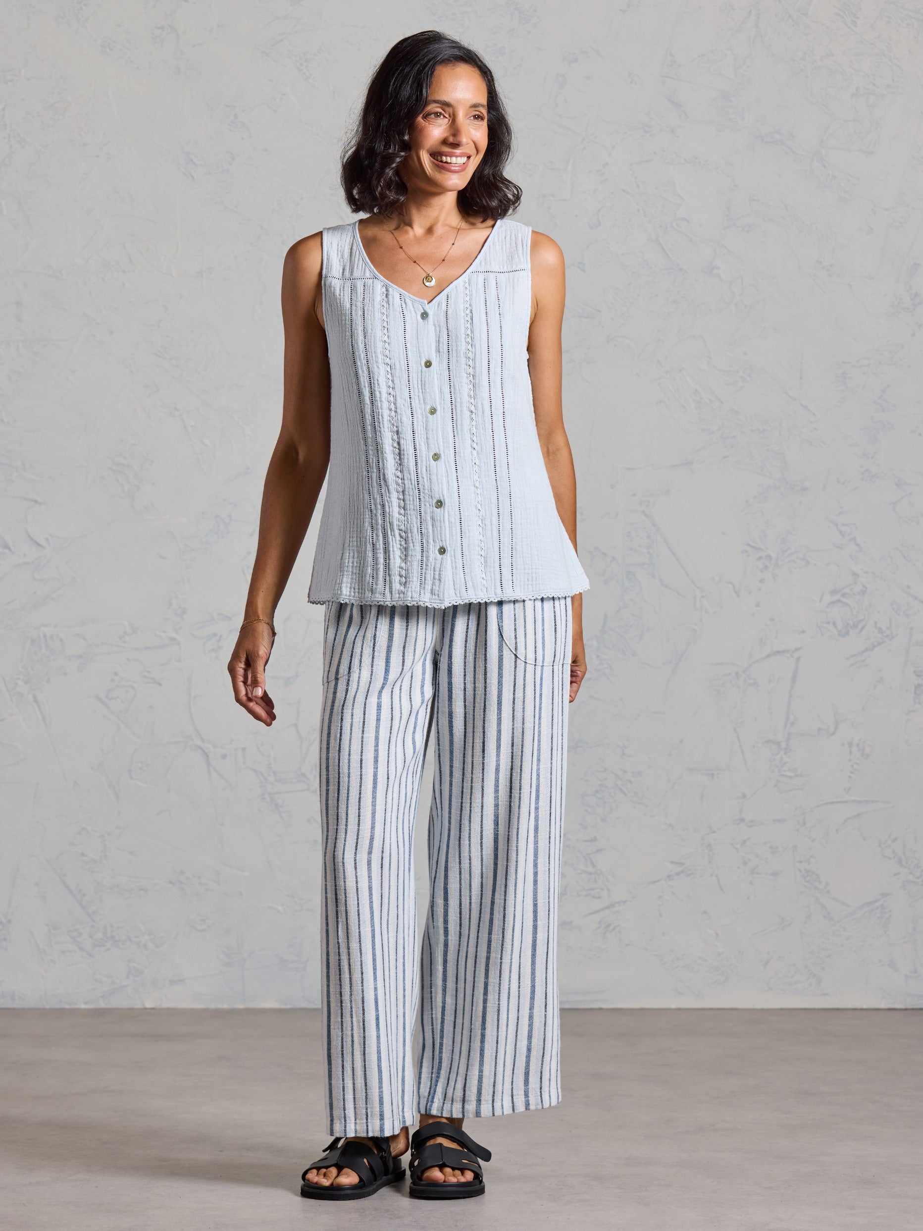 Full length view of the Ceres Organic Cotton Top in serene blue, paired with blue striped wide leg linen pants.