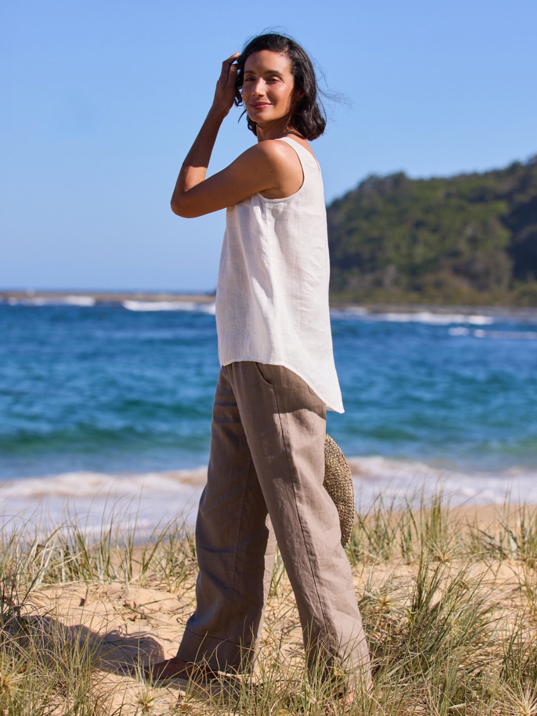 Woman standing on a beach with ocean and sky in the background