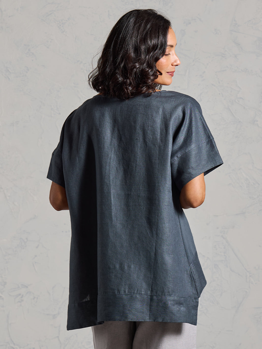 Woman wearing a dark t-shirt against a plain background