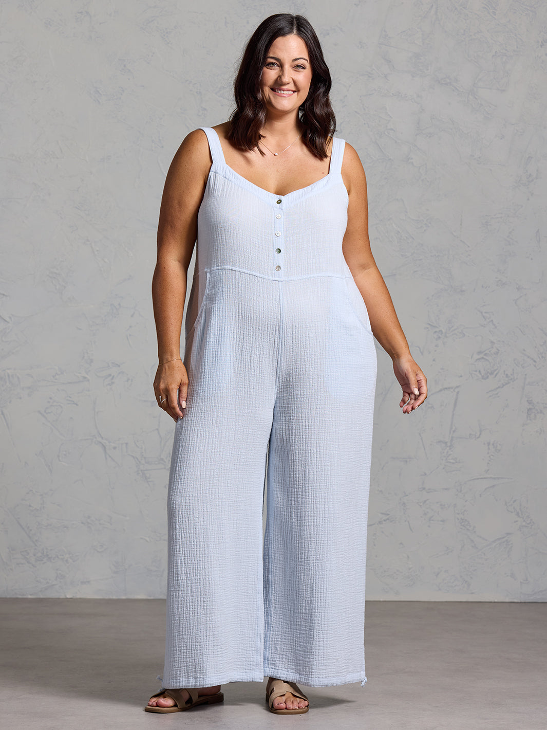A woman wearing a serene blue cotton jumpsuit from Nomad the Label