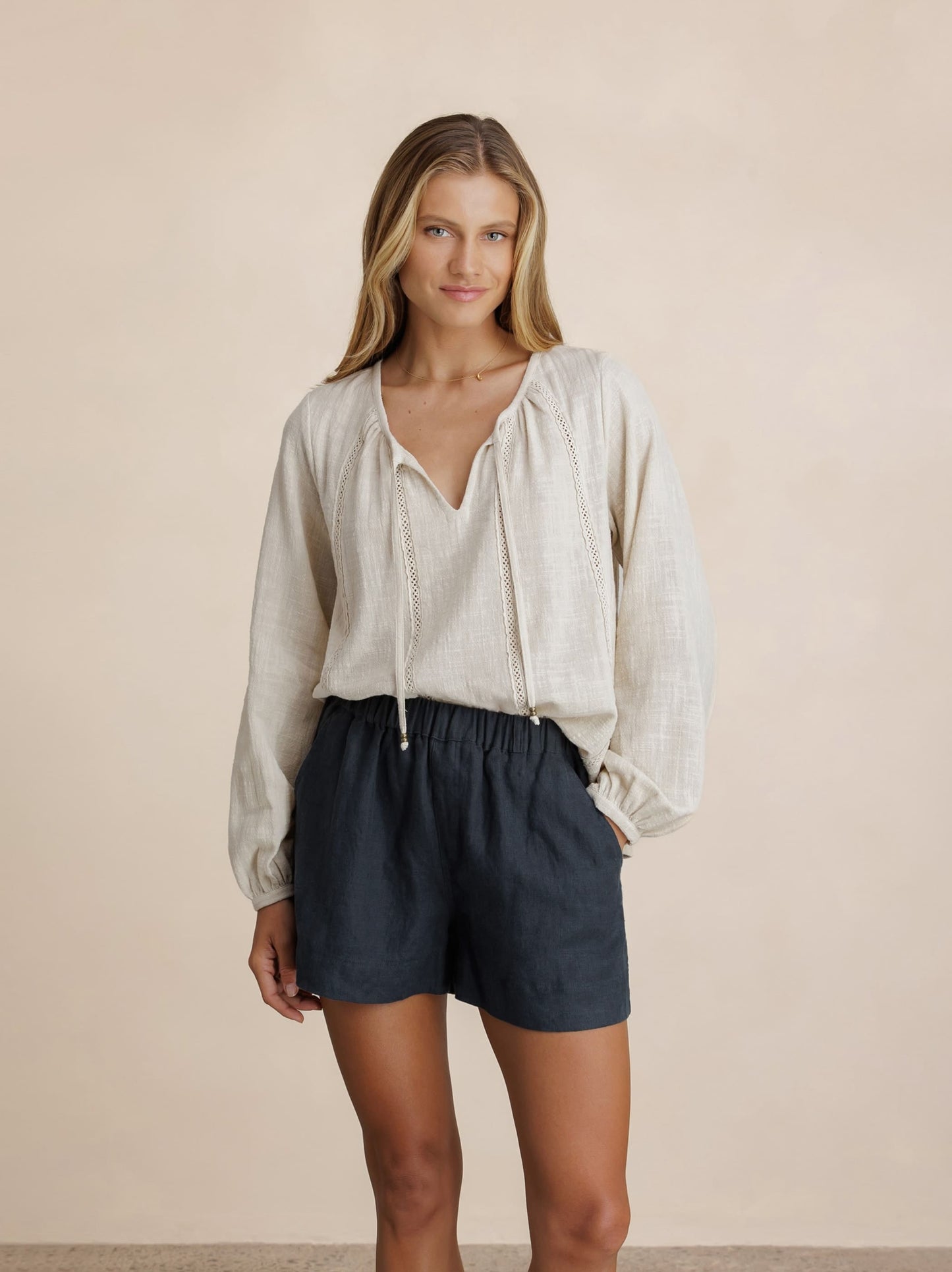 Model wears Dahlia Linen Shorts in Charcoal