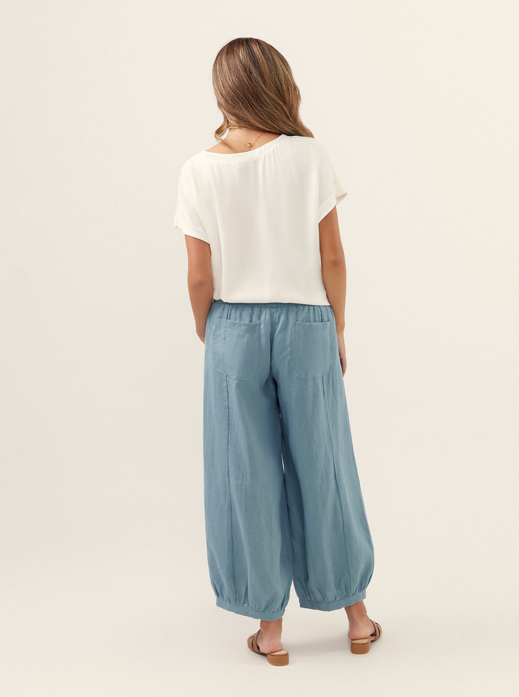 Model wears Sadhu French Linen Pants Regular in Tahiti Blue.