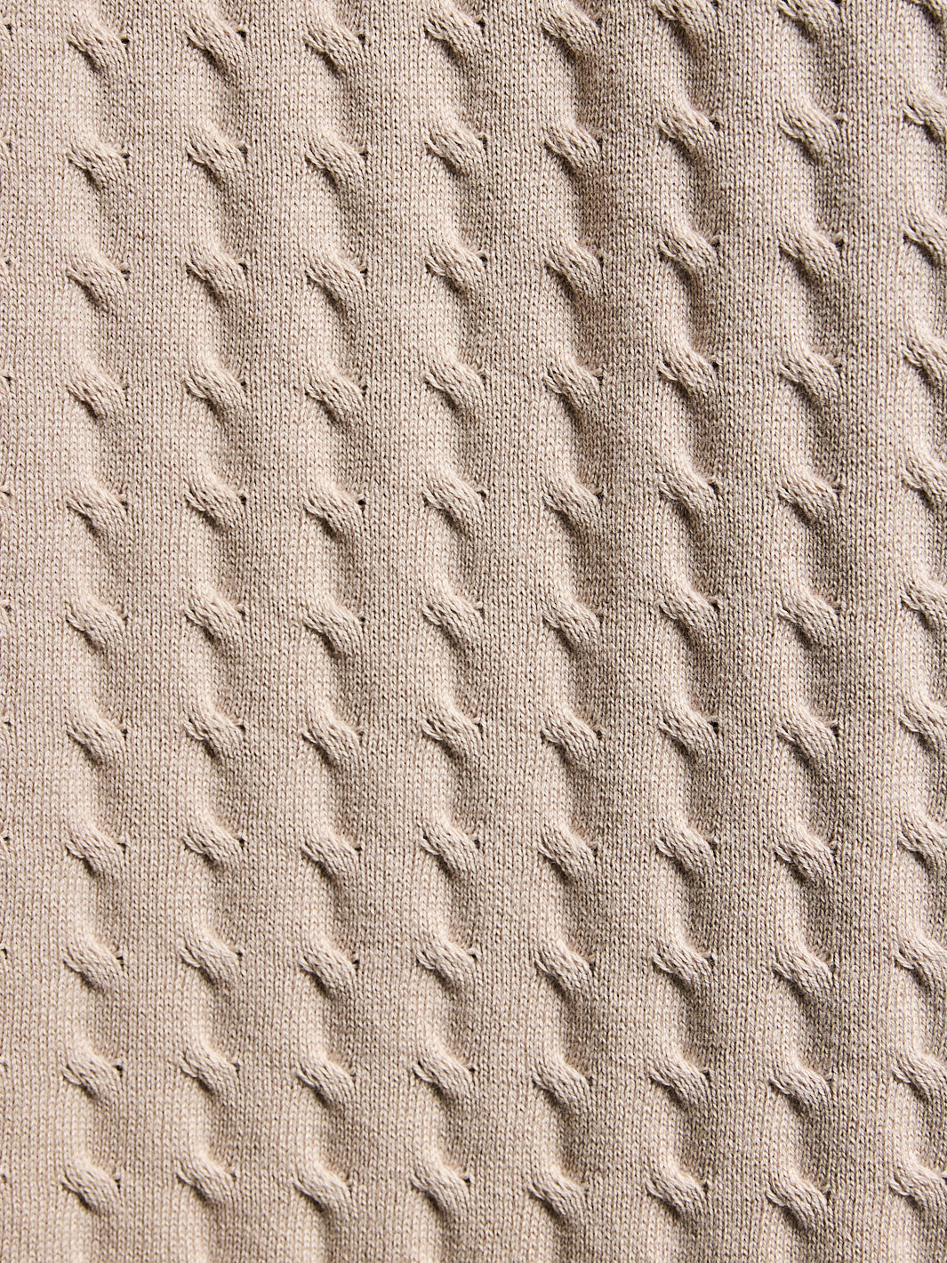 Close-up of textured beige fabric with a diamond pattern