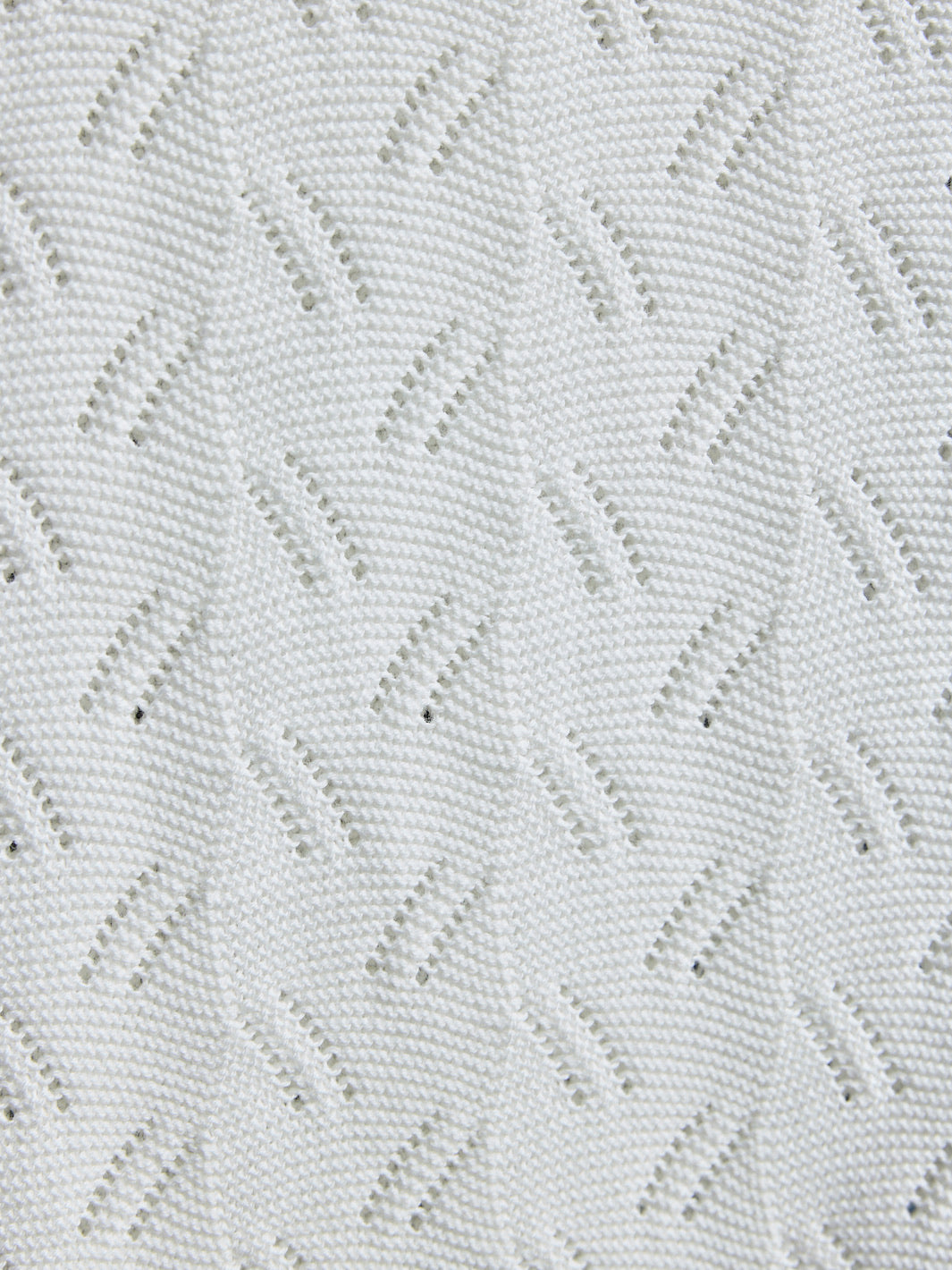 Close-up of a textured white fabric with a diamond pattern