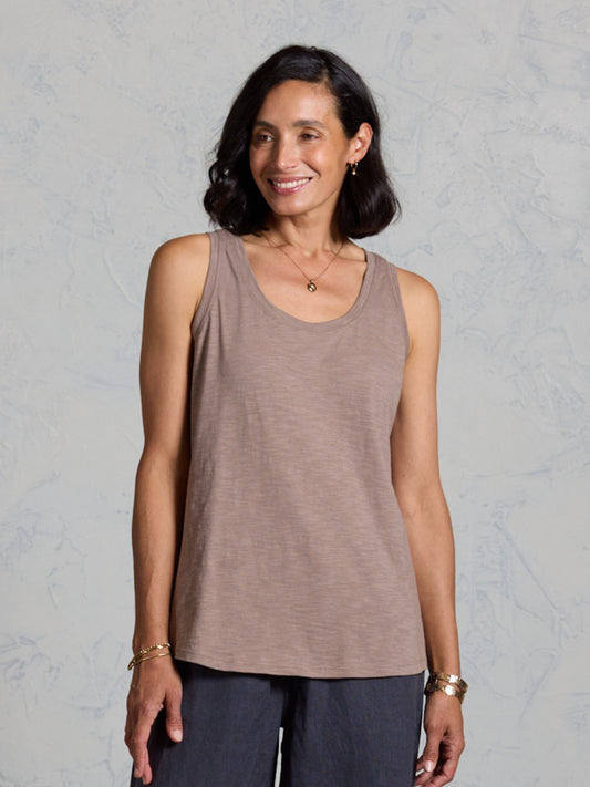 Woman wearing a brown tank top against a gray background